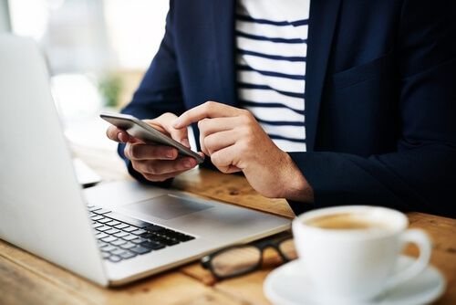 אדם יושב לצד מחשב נייד מיקרוסופט בזמן עבודה