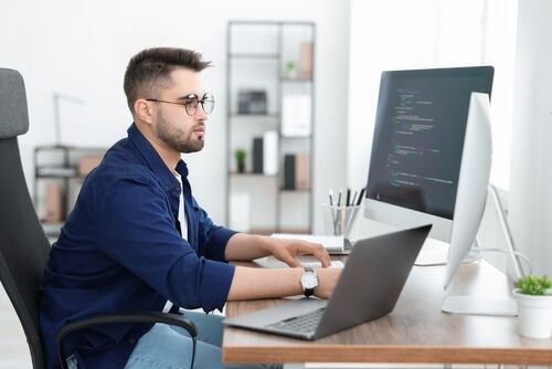 אדם עובד עם מסכים למחשב